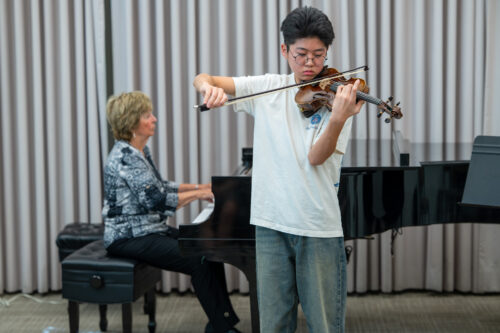 A student violinist performs with piano accompaniment