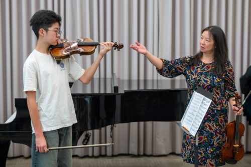 Maureen Yuen gestures while coaching a student violinist